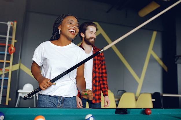 Foto grátis casal internacional jogando bilhar em um clube