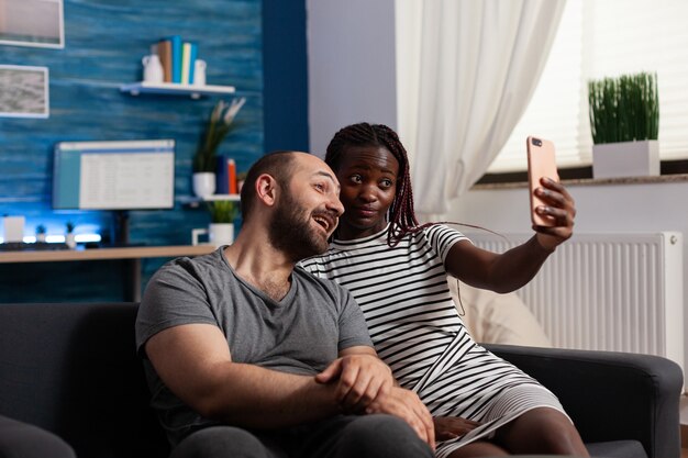 Casal interracial segurando smartphone para fotos