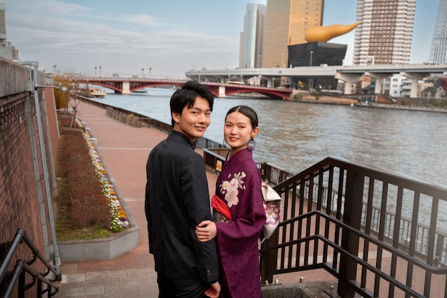 Foto grátis casal japonês posando na ponte e comemorando o dia da maioridade