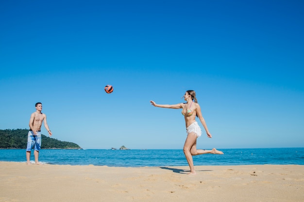 Casal jogando vôlei de praia