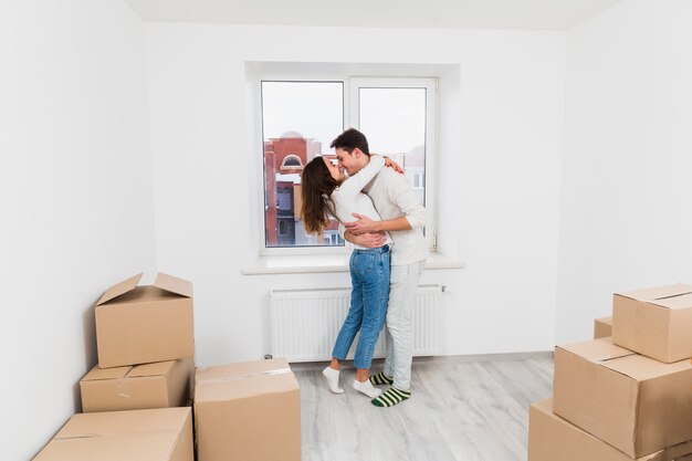 Casal jovem amoroso abraçando uns aos outros em seu novo apartamento