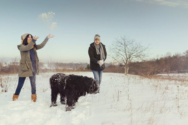 Casal jovem andando com um cachorro em um dia de inverno