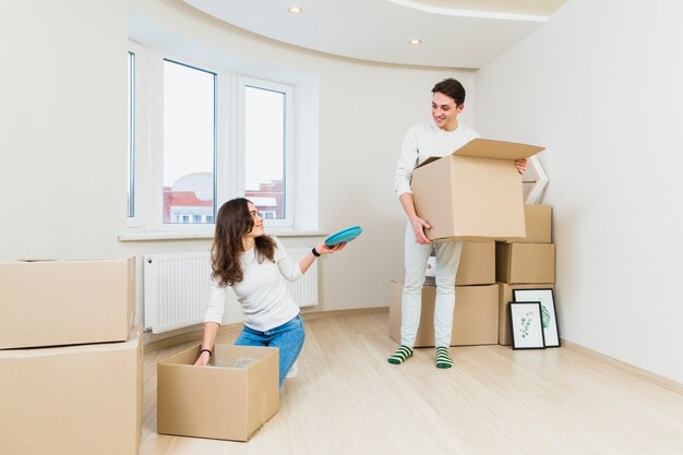 Casal jovem depois de se mudar para uma nova casa unboxing seus itens