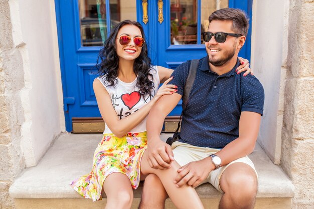 Casal jovem e bonito hippie apaixonado, sentado na rua da cidade velha