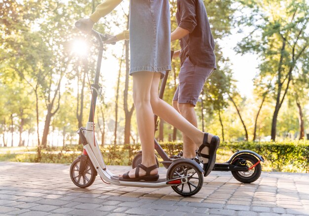 Casal jovem e fofo andando de scooter ao ar livre