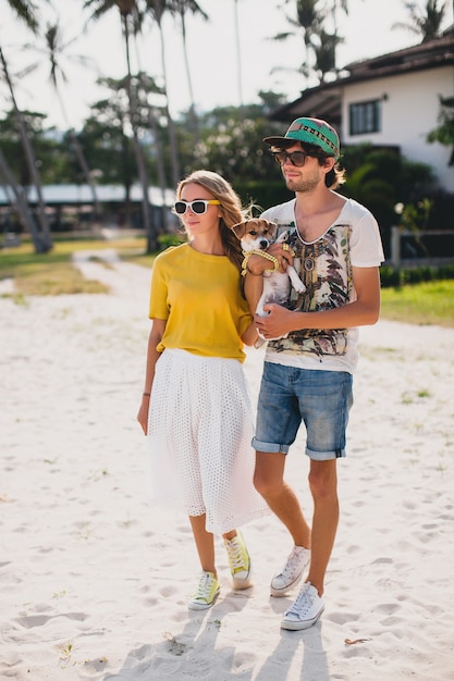 Casal jovem elegante e moderno apaixonado, andando e brincando de cachorro