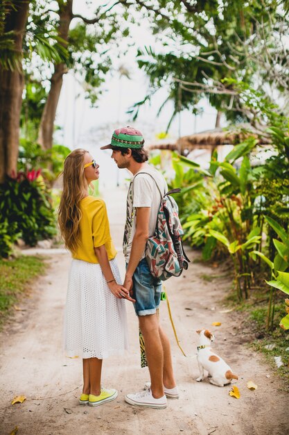 Casal jovem elegante hippie apaixonado de férias com cachorro e skate, se divertindo