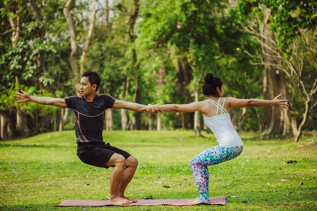 Foto grátis casal jovem fazendo ioga juntos na natureza