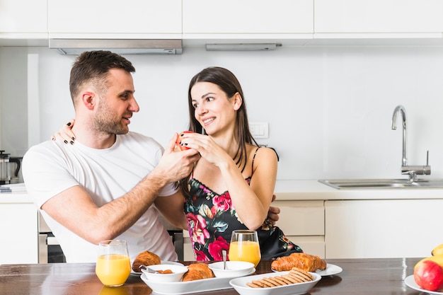 Casal jovem feliz, aproveitando o café da manhã juntos