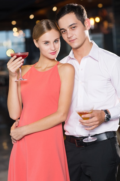 Foto grátis casal jovem feliz com cocktails no partido