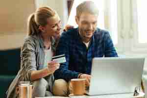 Foto grátis casal jovem feliz compras em casa enquanto estiver usando computador e cartão de crédito.