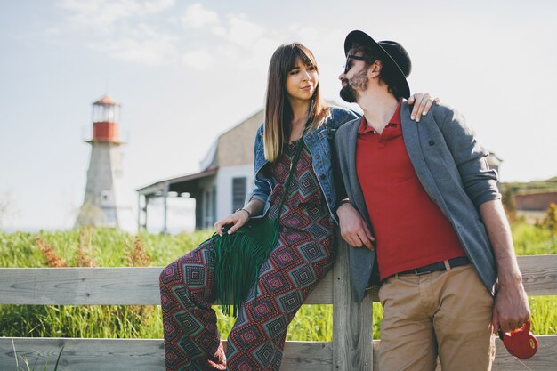 Casal jovem hippie estilo indie apaixonado caminhando pelo campo