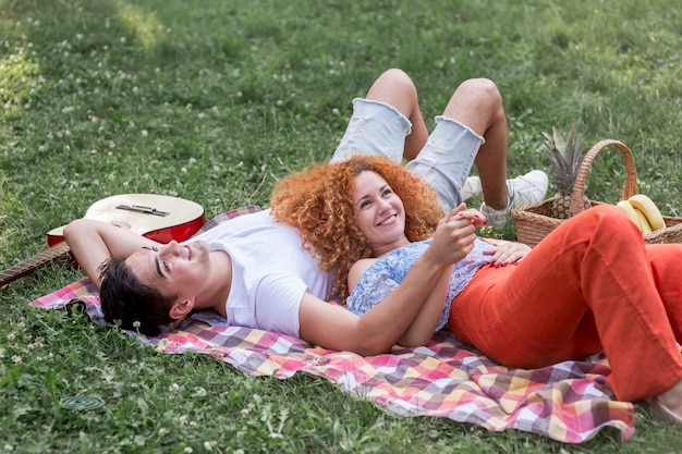 Casal jovem romântico piqueniques juntos no parque