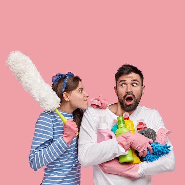 Casal jovem segurando produtos de limpeza