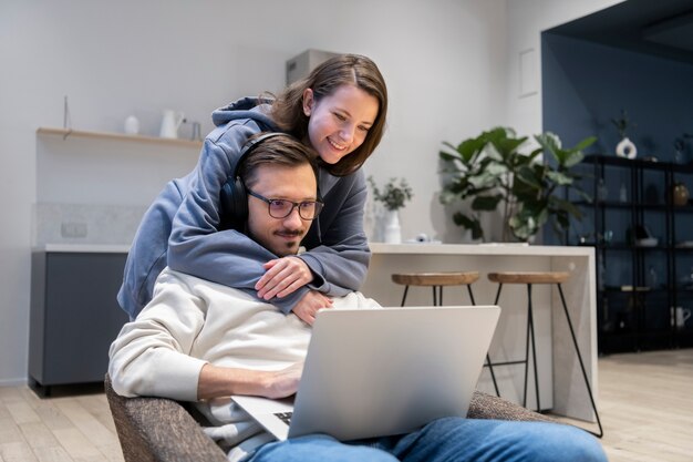 Casal juntos na cozinha trabalhando em um laptop