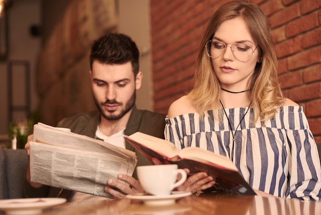 Casal lendo papel e livro