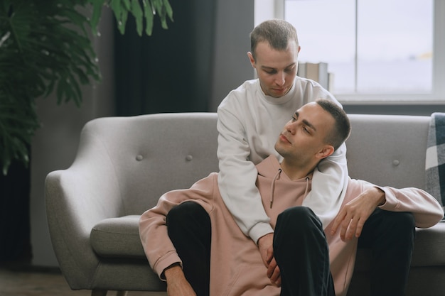 Casal LGBTQ relaxando no sofá. Conceito de estilo de vida familiar diferente.