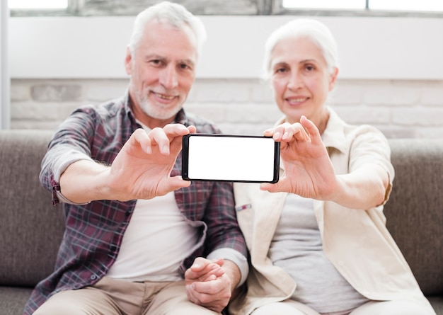 Casal mais velho mostrando um smartphone