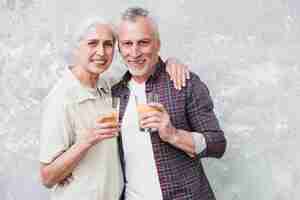 Foto grátis casal mais velho posando com suco