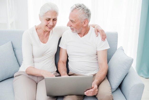 Casal mais velho usando um laptop