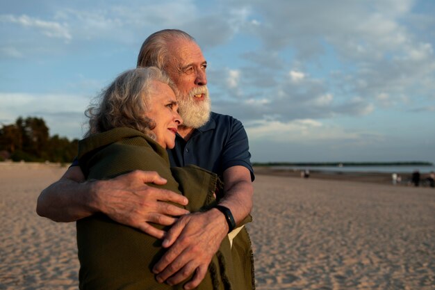 Casal mediano se abraçando na praia