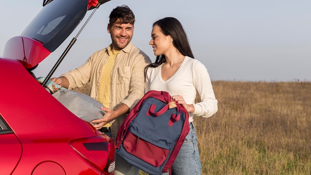 Casal médio com mochilas ao ar livre