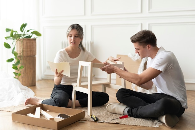 Casal montando uma cadeira diy do zero