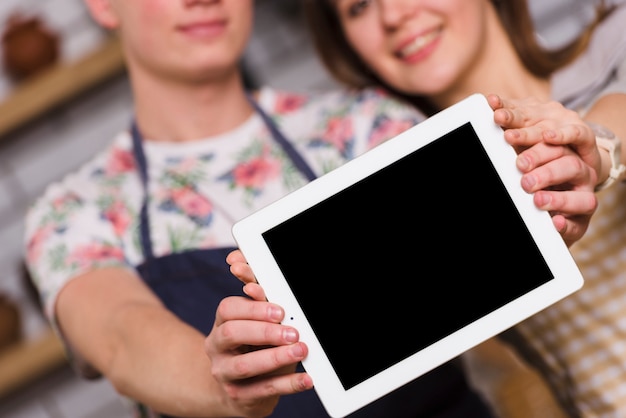 Casal mostrando tablet moderno juntos