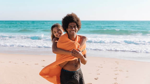 Casal multiétnico abraçando na praia