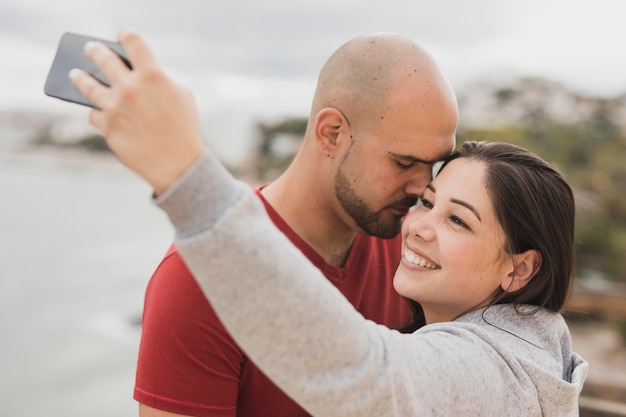 Foto grátis casal na beira-mar tomando selfie