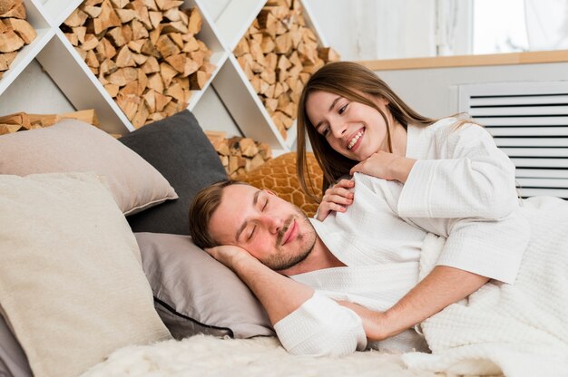 Casal na cama vestindo roupões acordando