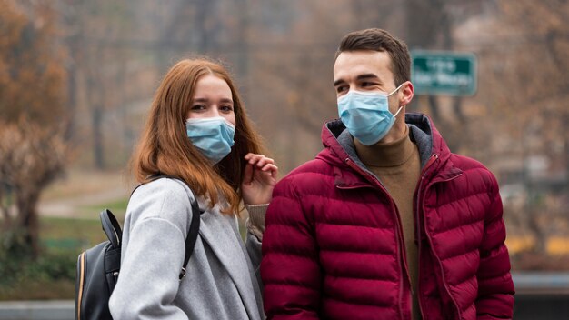 Casal na cidade usando máscaras médicas