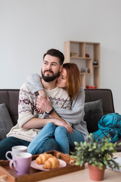 Casal na sala de estar abraçando