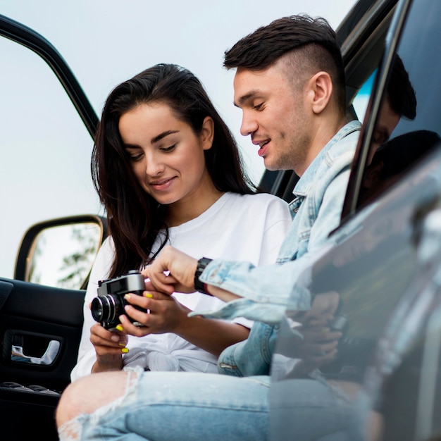 Foto grátis casal olhando fotos em uma viagem de carro com vista panorâmica