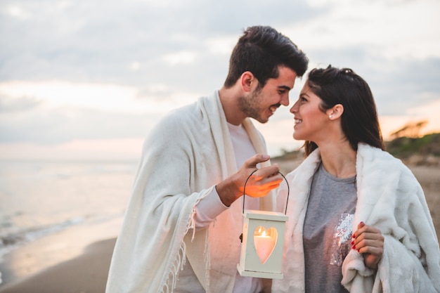 Casal olhando para o outro com uma vela na mão