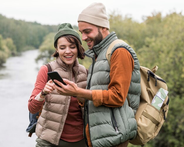 Foto grátis casal olhando para o telefone na natureza