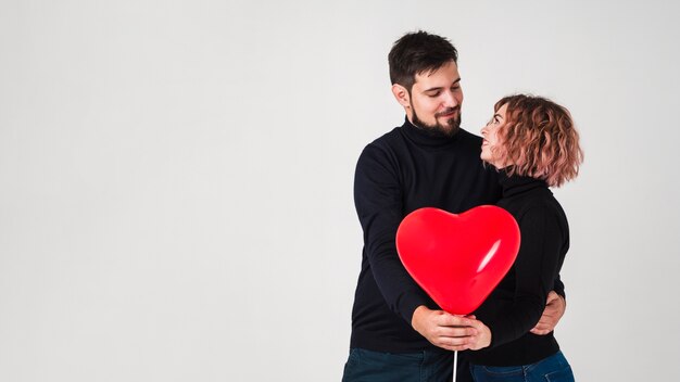 Casal posando com balão para dia dos namorados e copie o espaço