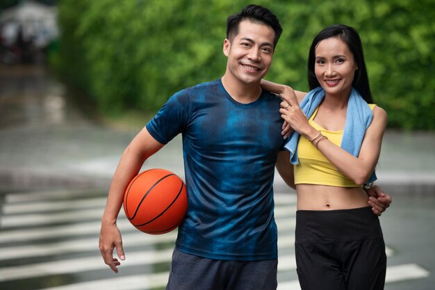 Casal posando juntos ao ar livre com basquete