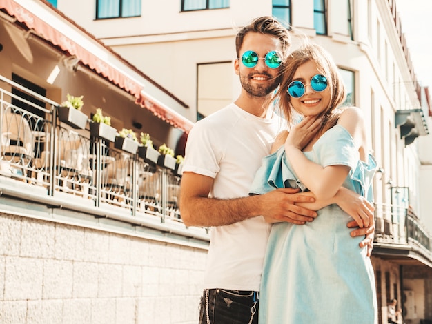 Casal posando na rua em óculos de sol