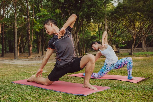 Casal, pose de yoga e natureza