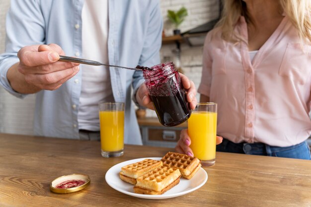 Casal próximo com waffles e geléia