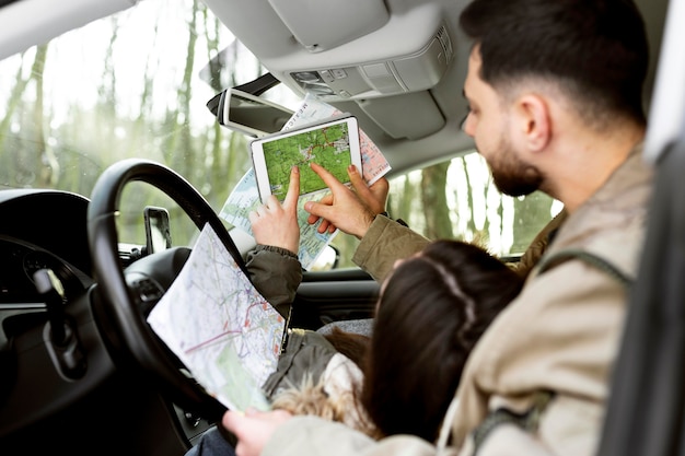 Casal próximo no carro com mapas