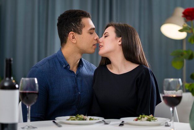 Casal quase se beijando no jantar romântico