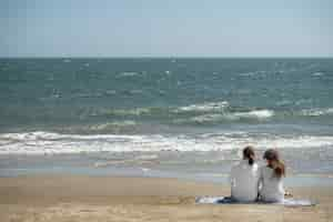 Foto grátis casal relaxando na praia durante as férias