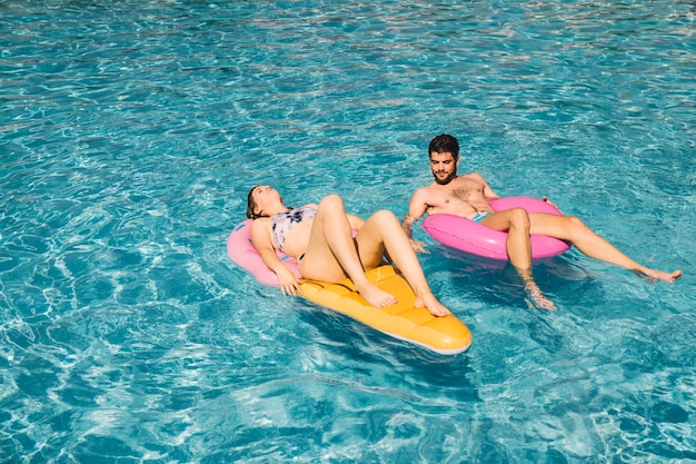 Casal relaxante na piscina