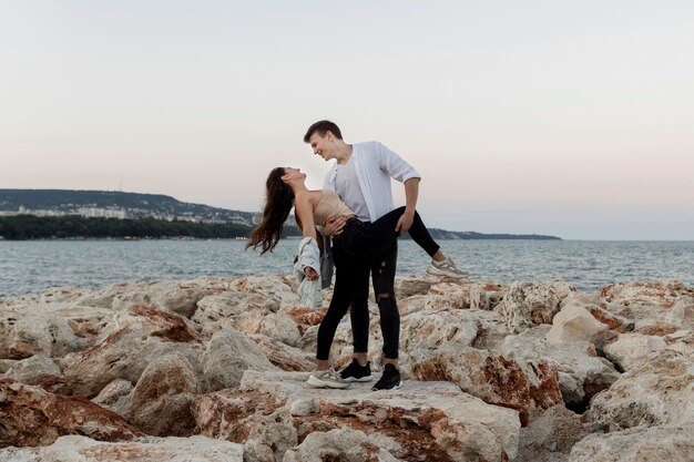 Casal romântico abraçado à beira-mar