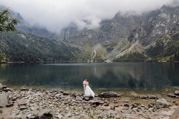 Casal romântico casamento apaixonado pé do lago Sea Eye na Polônia. Montanhas Tatra.