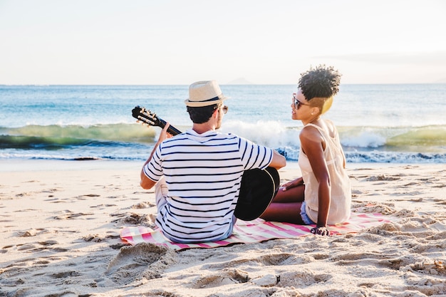Casal romântico com guitarra na praia