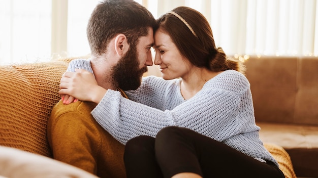 Casal romântico em plano médio no sofá