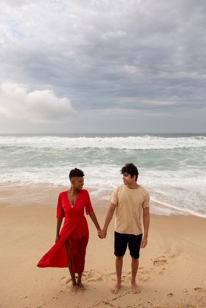 Casal romântico mostrando carinho na praia perto do oceano